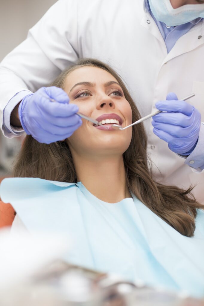 Pretty brunette woman sitting in the dental chair with her dentist, emphasizing the attentive care at Schlueter Periodontics.