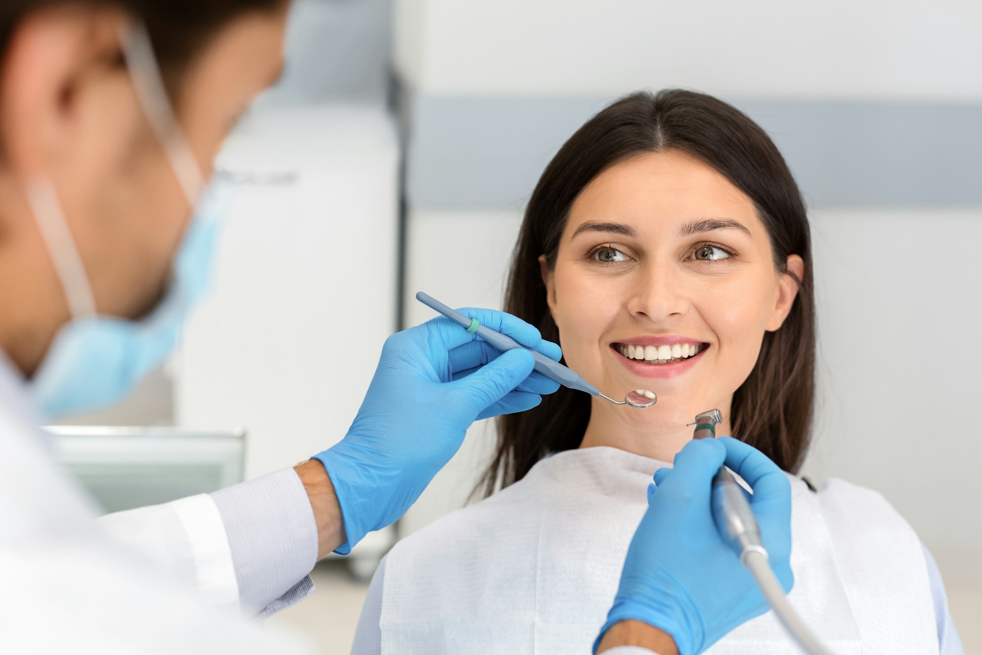 Woman smiling during a dental visit, illustrating the positive experience of Guided Tissue Regeneration at Schlueter Periodontics.